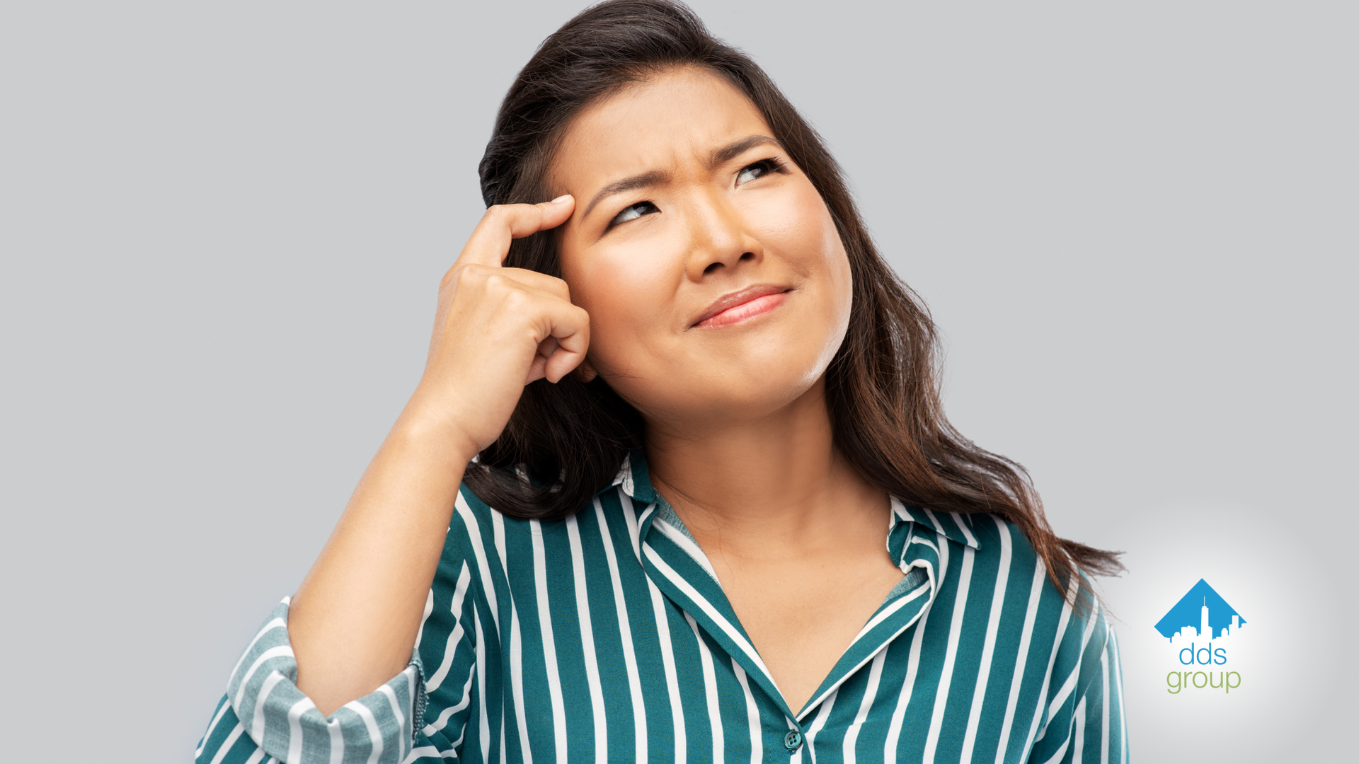 A woman in a striped shirt is scratching her head.