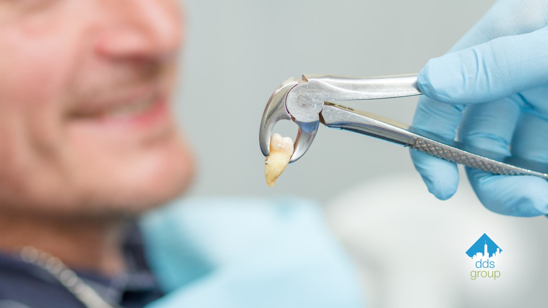 A dentist is removing a tooth from a patient's mouth with a pair of pliers.