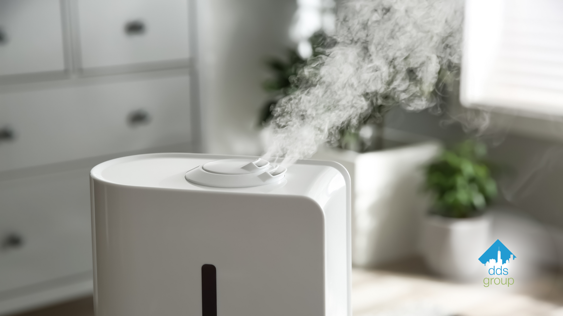 A white humidifier is sitting on a wooden floor in a room.