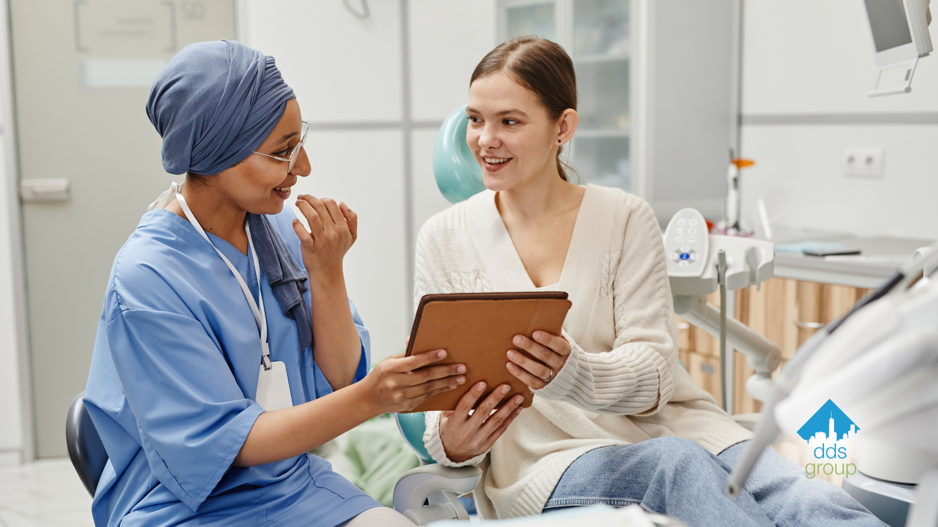 A nurse is talking to a patient who is holding a tablet.