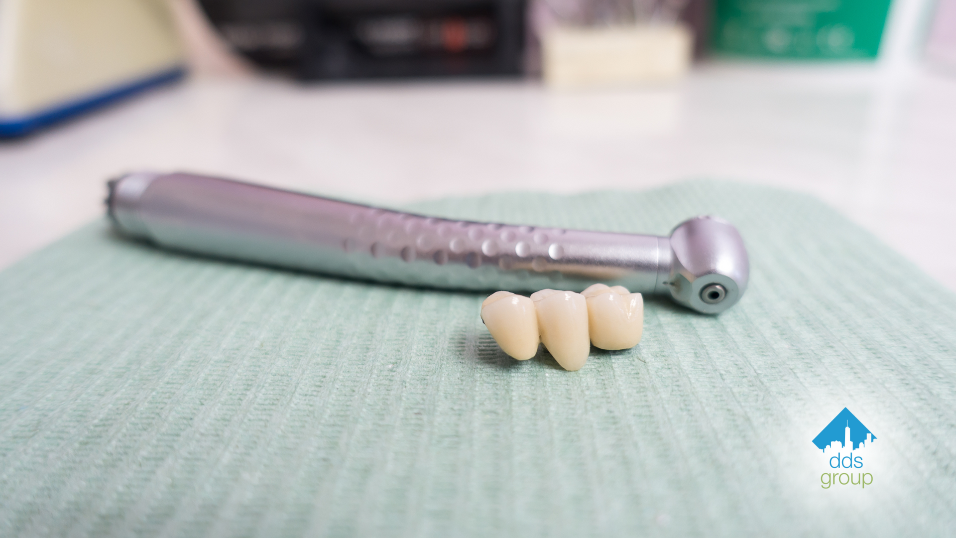 A close up of a dental drill and dental crowns on a table.