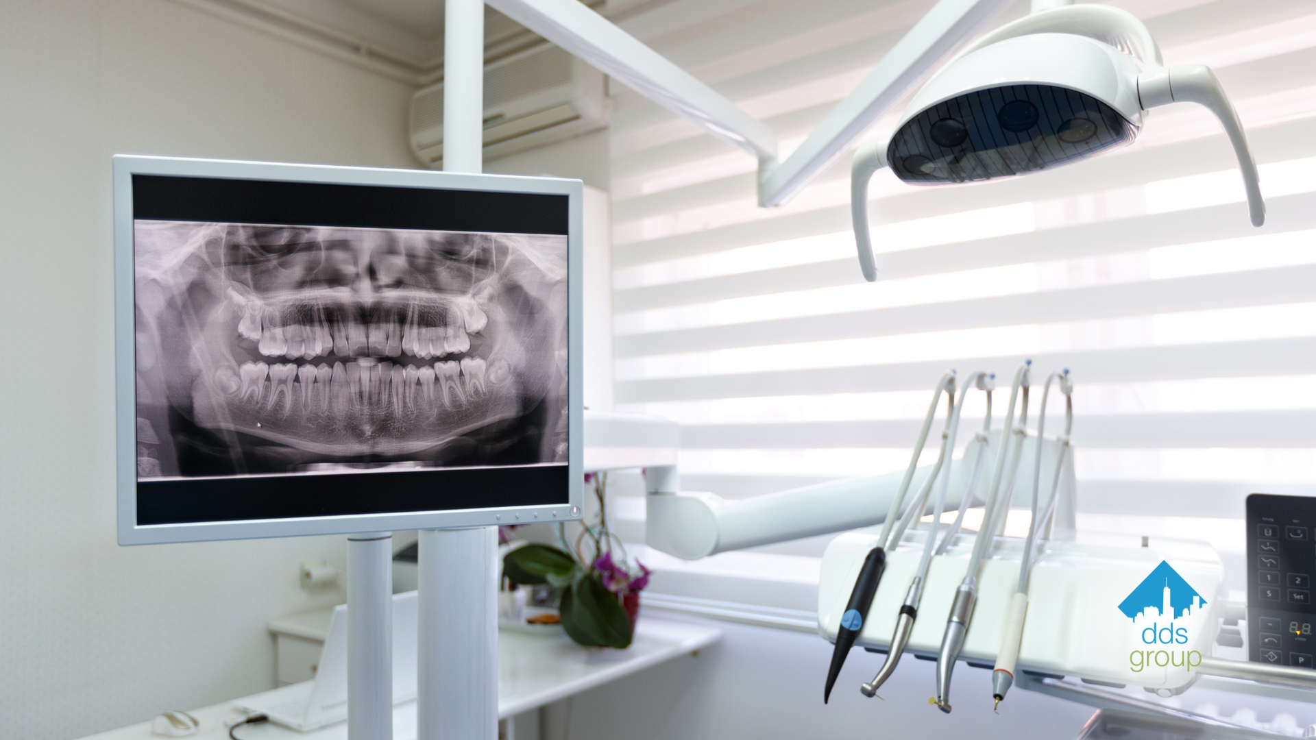 A dental office with a monitor showing an x-ray of a person 's teeth.