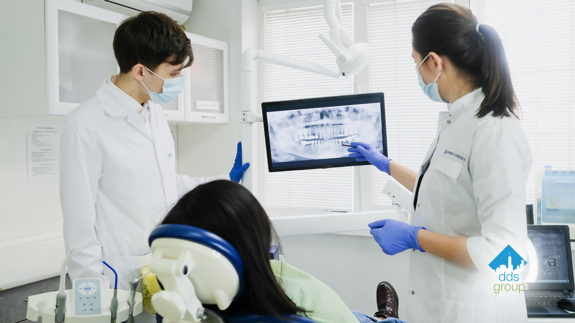A dentist is looking at an x-ray of a patient 's teeth.