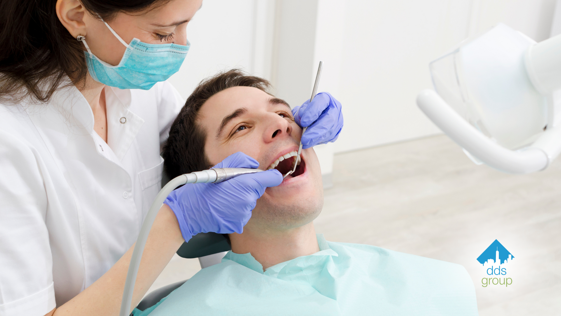 A man is getting his teeth examined by a female dentist.