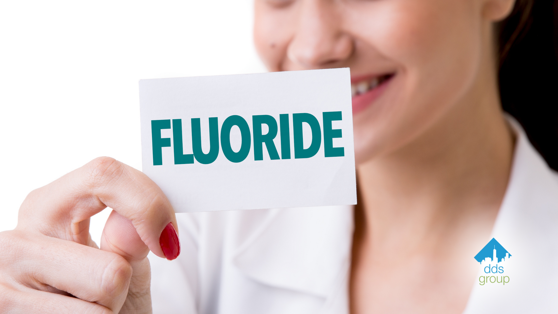 A woman is holding a card with the word fluoride on it.