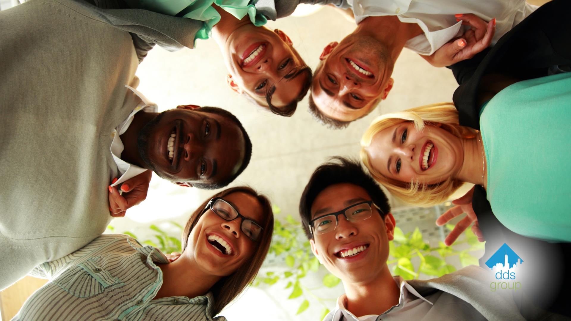 A group of people are standing in a circle and smiling