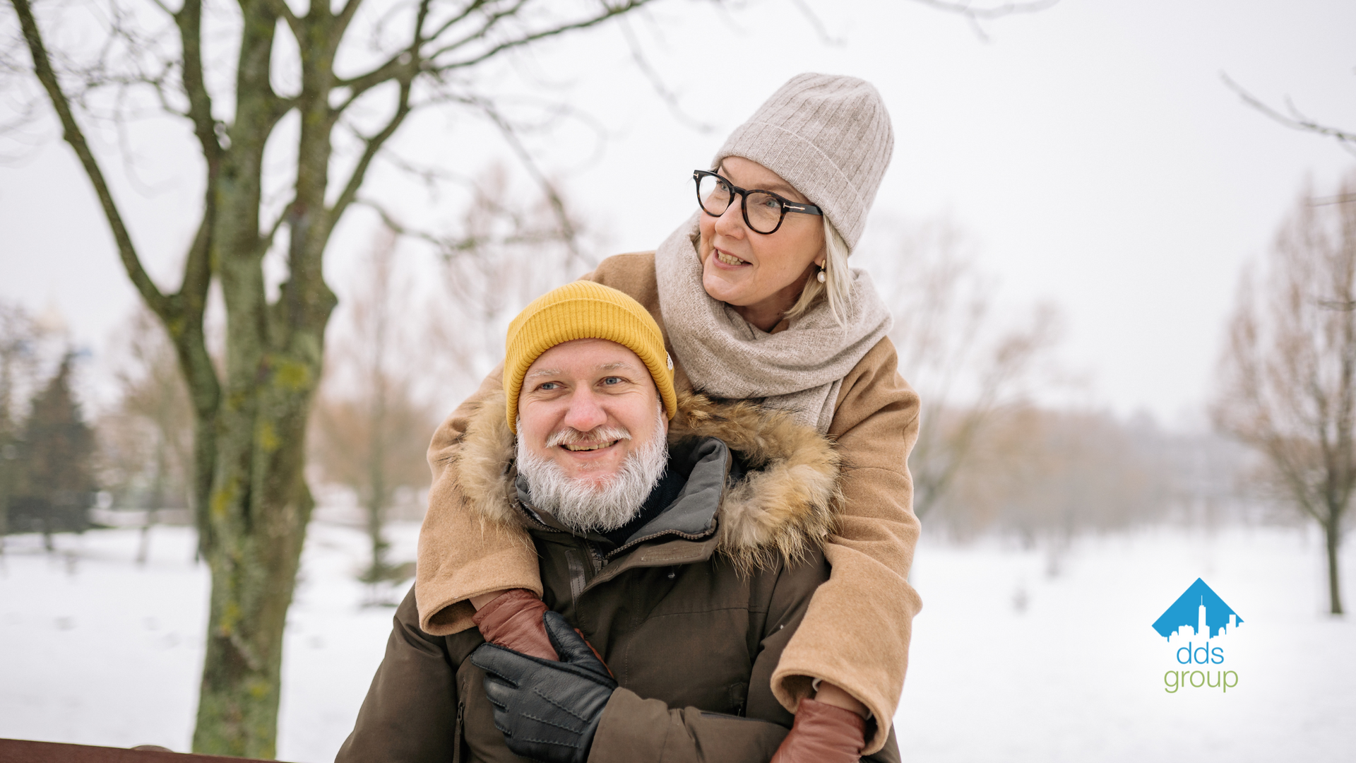 A man is carrying a woman on his shoulders in the snow.