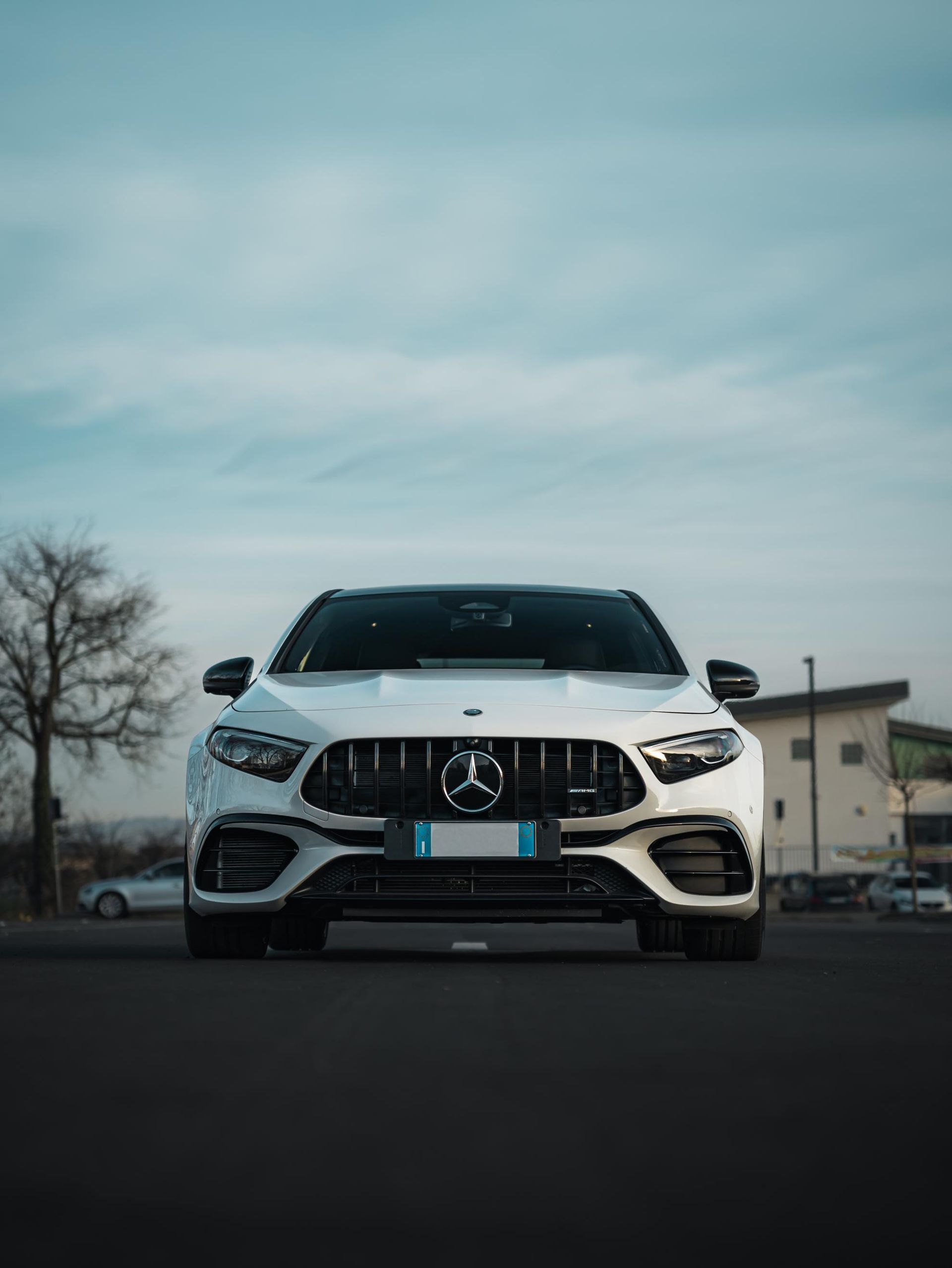 Una mercedes benz bianca è parcheggiata in un parcheggio.