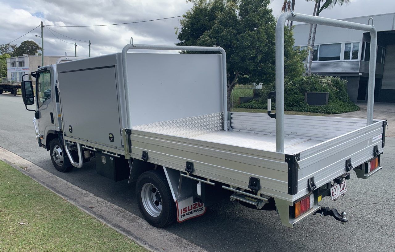 A silver truck with a flat bed is parked on the side of the road. — Keystone Engineering Sheet Metal Industries in Noosaville, QLD