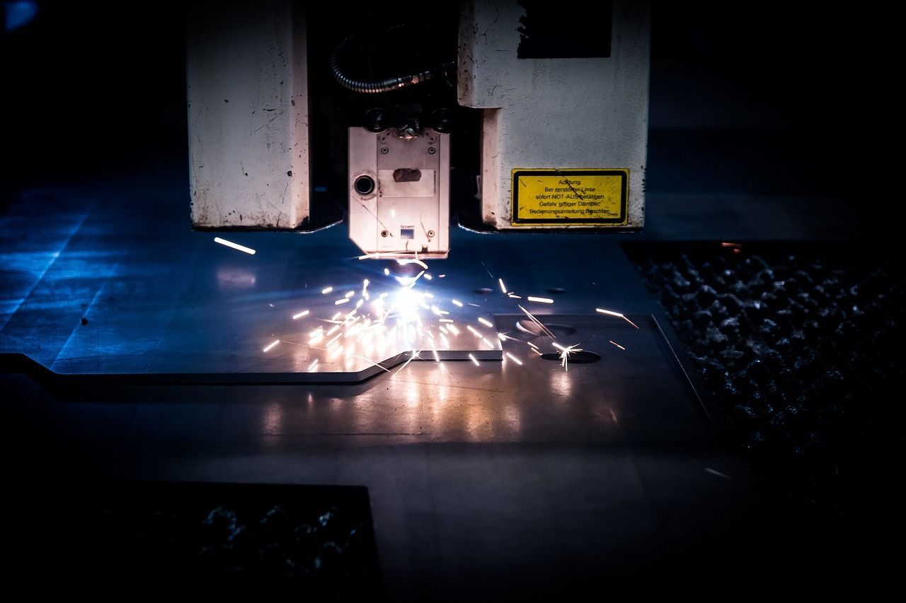 A machine is cutting a piece of metal with sparks coming out of it. — Keystone Engineering Sheet Metal Industries in Noosaville, QLD