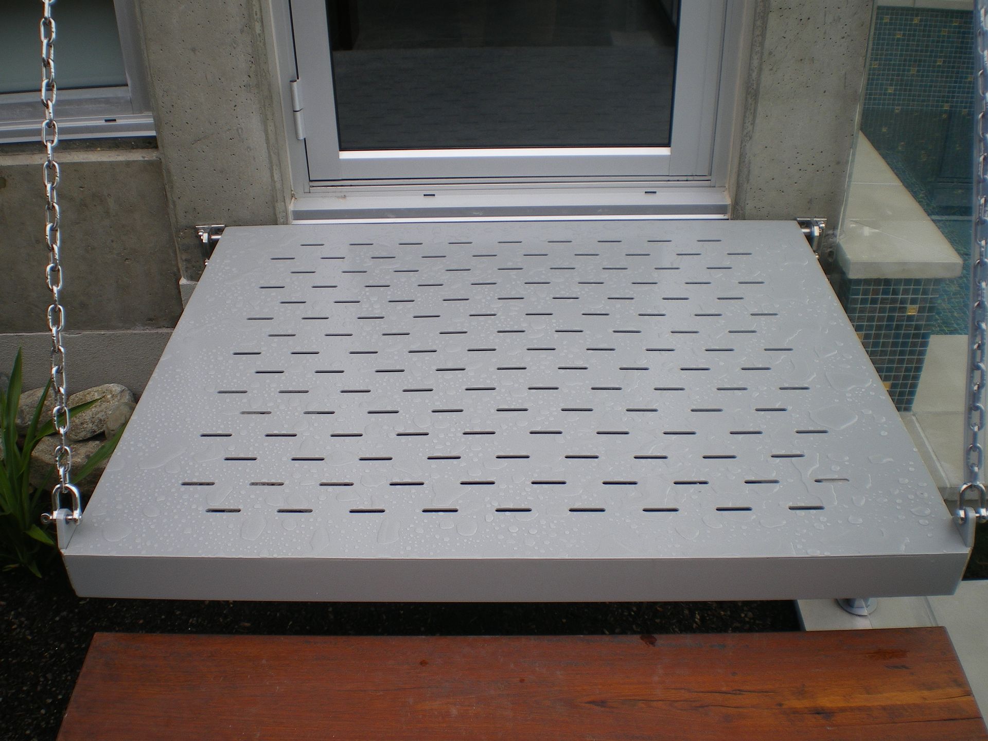 A metal platform with holes in it is attached to a chain — Keystone Engineering Sheet Metal Industries in Noosaville, QLD