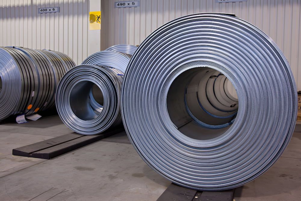 A Bunch Of Metal Rolls Are Stacked In A Warehouse — Keystone Engineering Sheet Metal Industries in Noosaville, QLD
