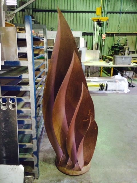A large sculpture of a flame is sitting in a warehouse — Keystone Engineering Sheet Metal Industries in Noosaville, QLD