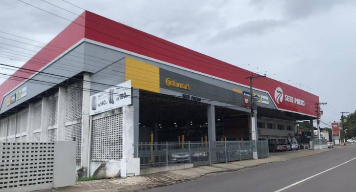 Mulher sentada à mesa em uma loja de pneus Bridgestone, falando ao telefone.