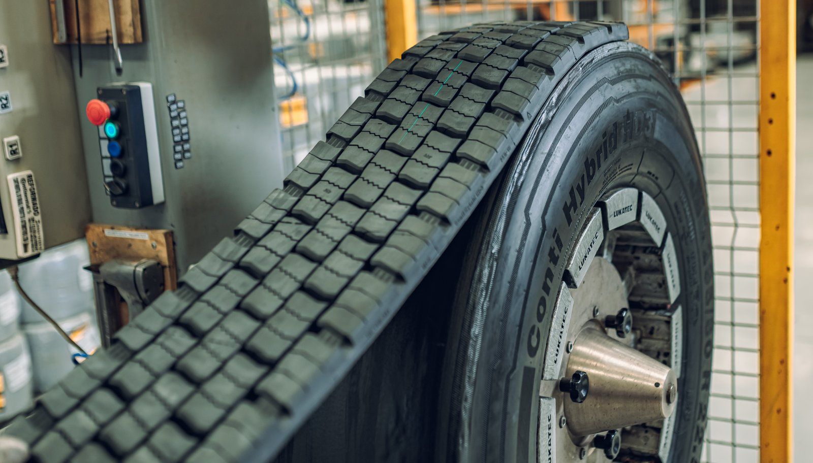 Oficina mecânica com carros em elevadores e mecânicos trabalhando. A marca Bridgestone está visível.