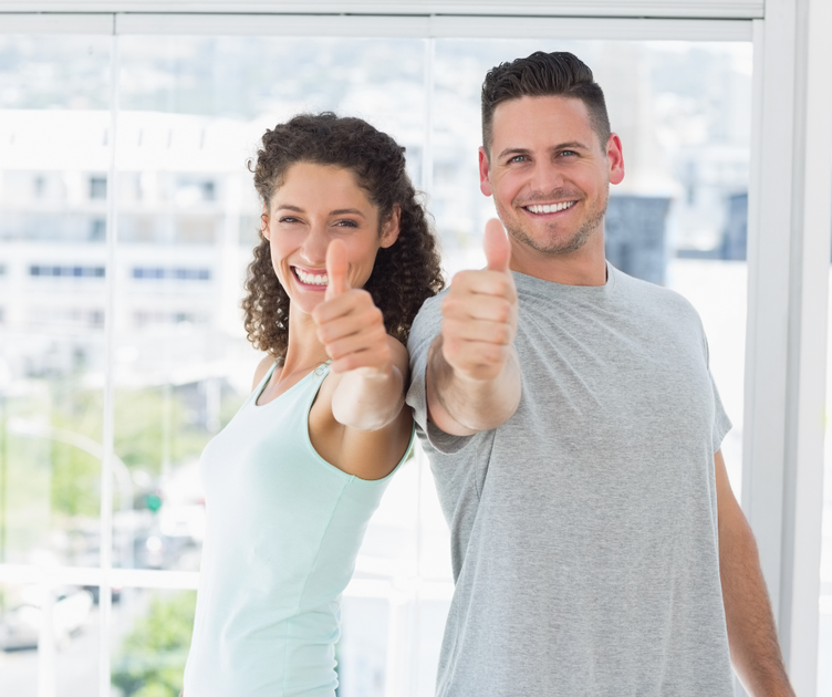 Health and young male and female smiling with their thumbs up
