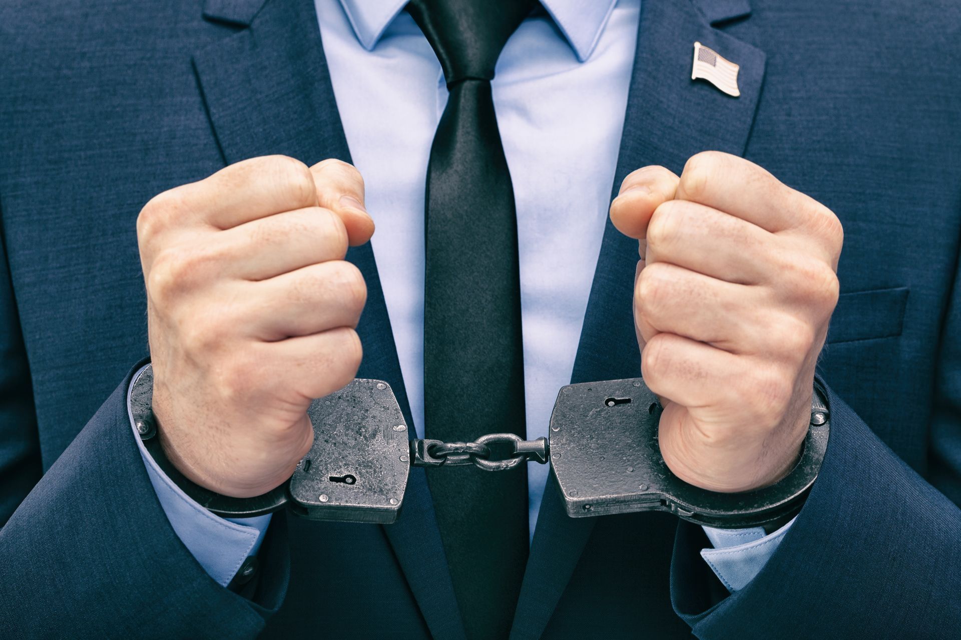 Man in suit with handcuffs.