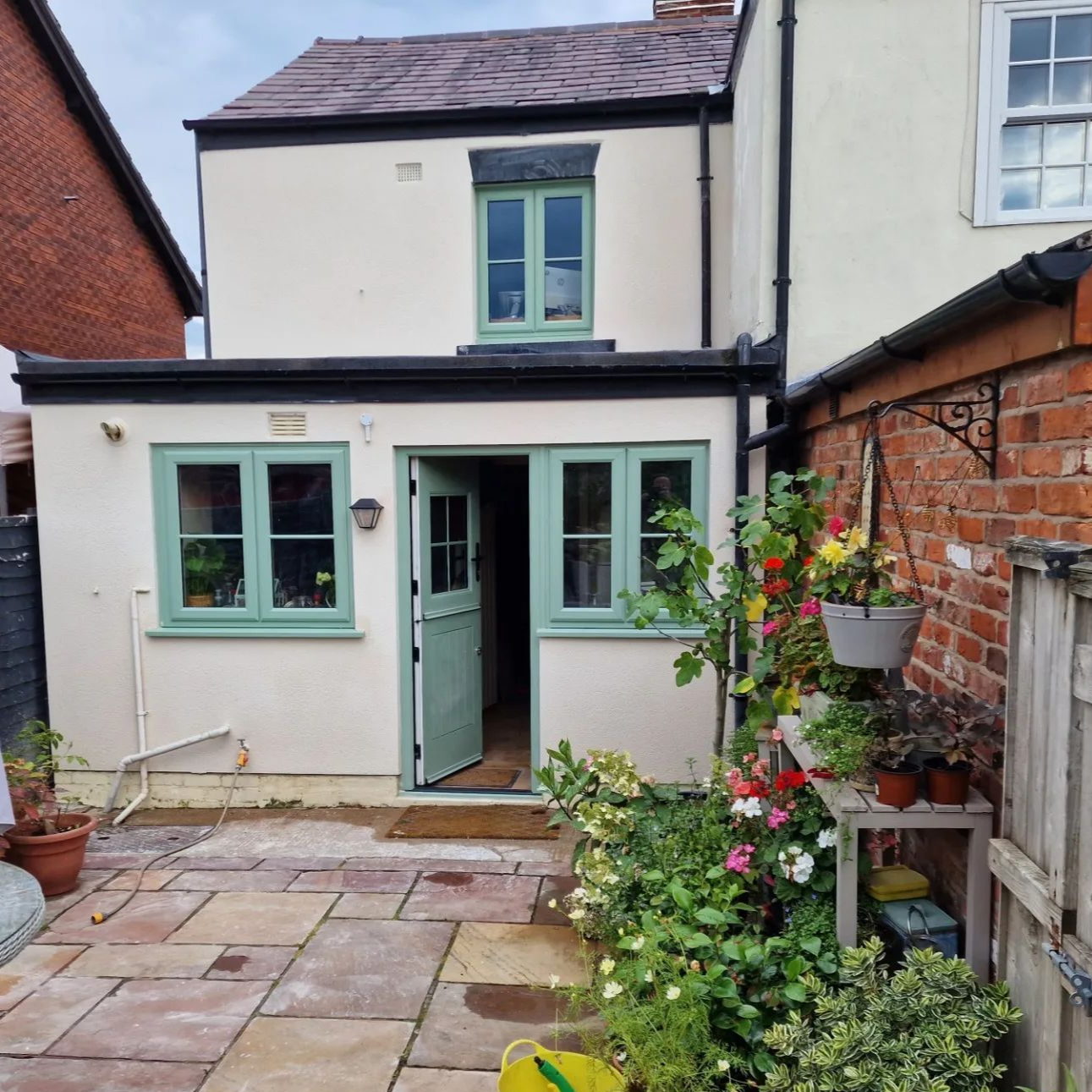 Room under renovation: gray walls, white ceiling, door frame, exposed wires, green floor covering.