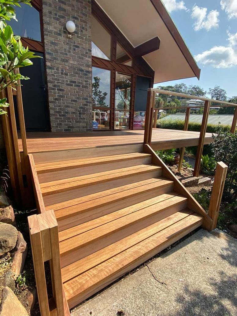 A Wooden Deck With Stairs Leading Up To A House — B Smart Building & Design In Shellharbour, NSW