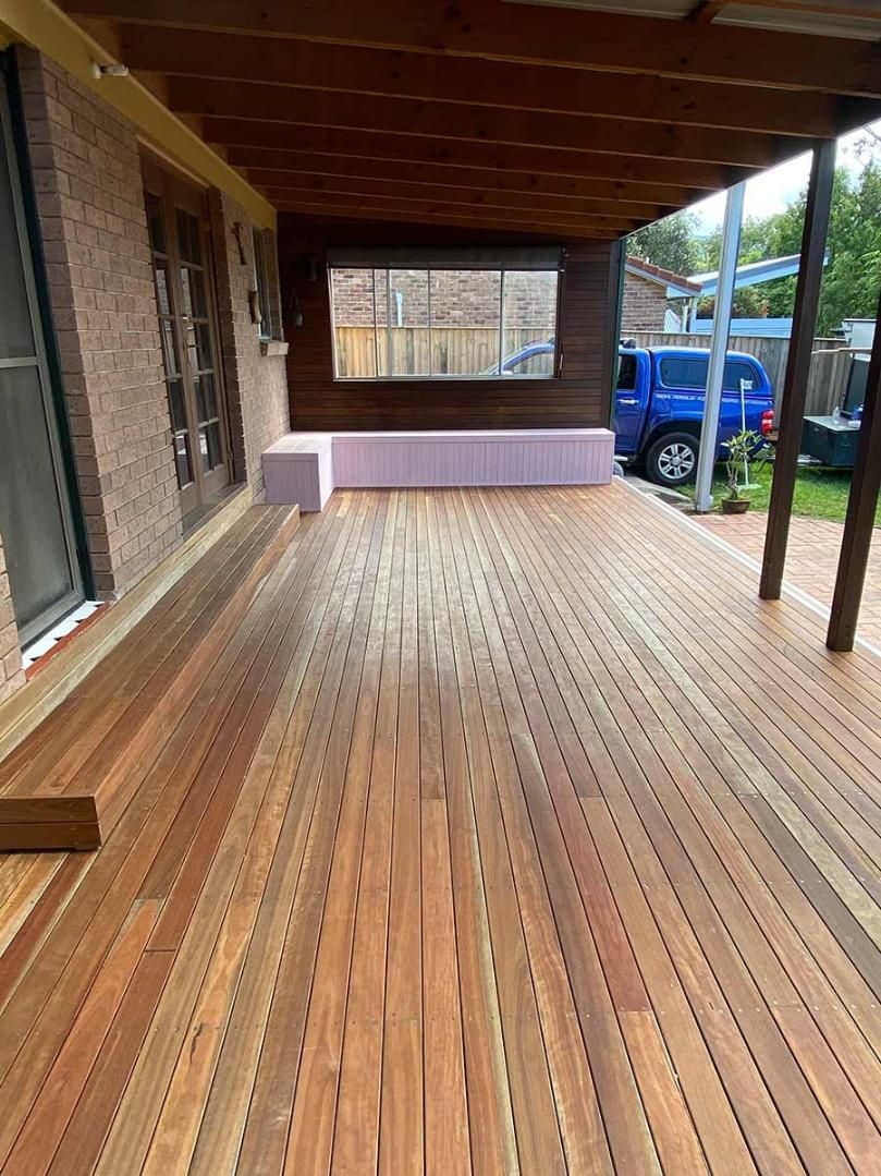 A Large Wooden Deck With A Bench Underneath It — B Smart Building & Design In Balgownie, NSW