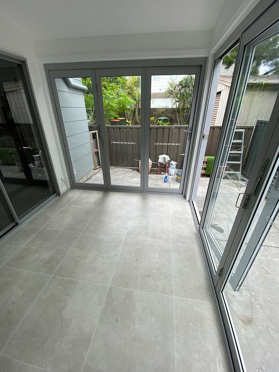 A Room With A Lot Of Windows And Sliding Glass Doors Leading To A Patio — B Smart Building & Design In Shellharbour, NSW