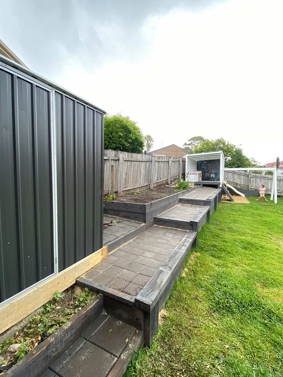 A Backyard With A Fence , Stairs , And A Shed — B Smart Building & Design In Gerringong, NSW