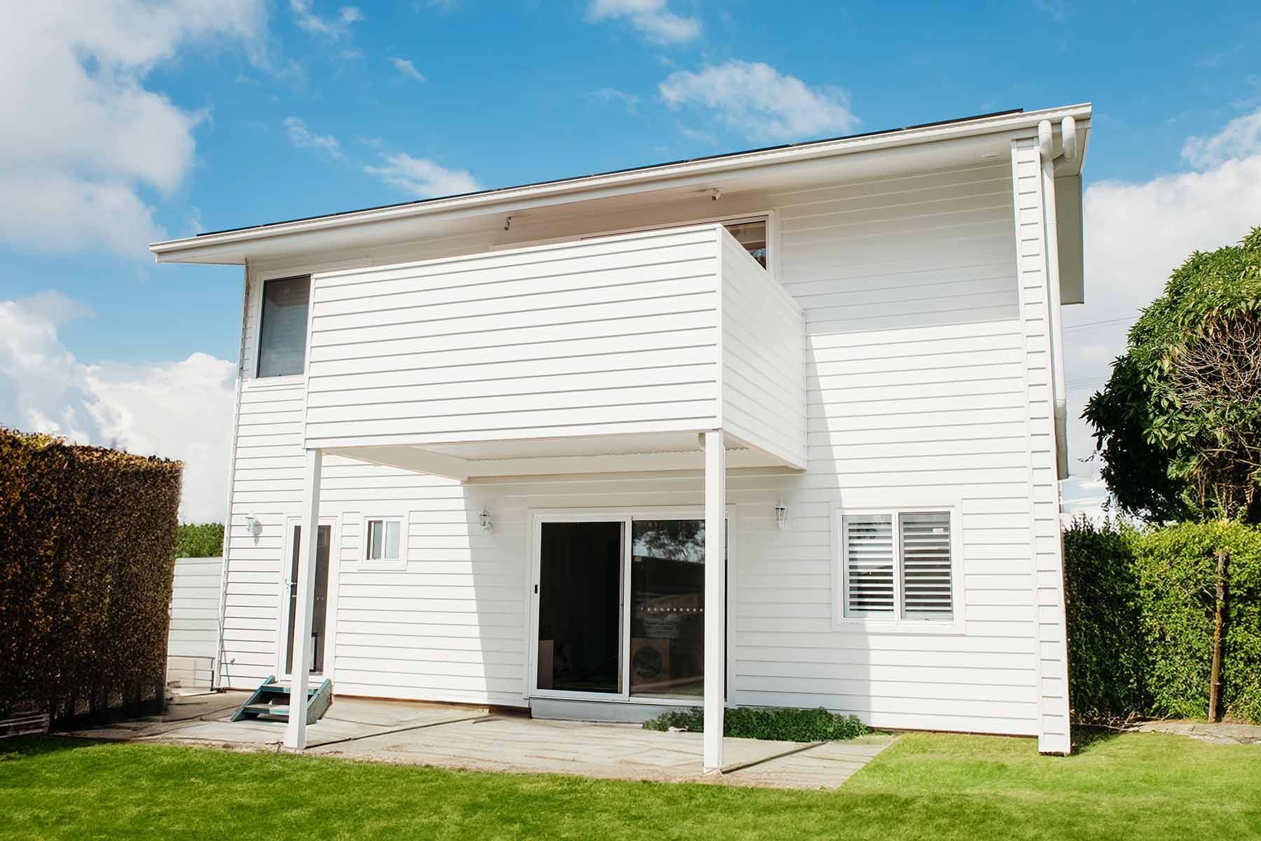 A White House With A Lush Green Lawn In Front Of It — B Smart Building & Design In Shellharbour, NSW