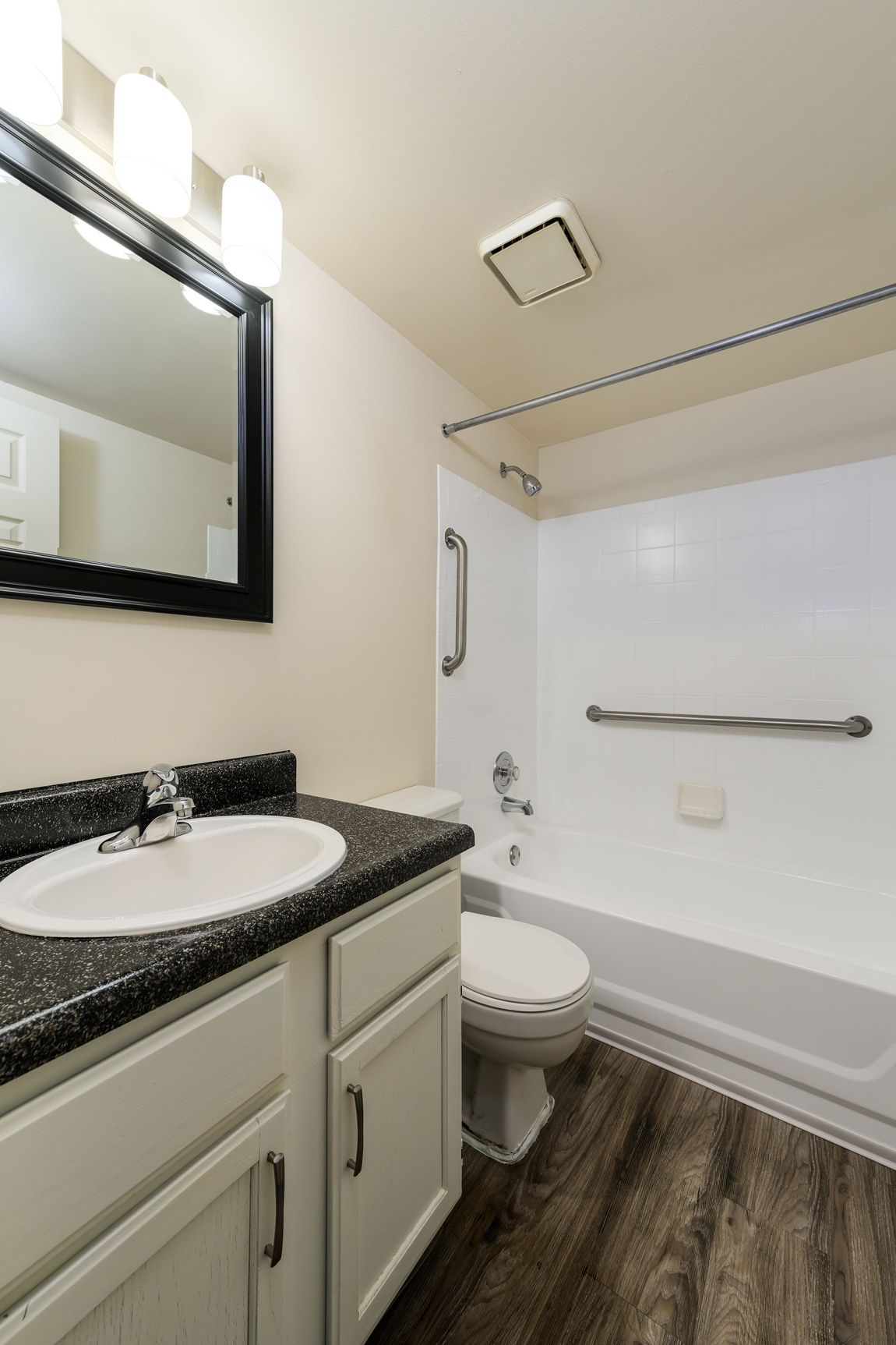 A bathroom with a sink , toilet , bathtub and mirror.