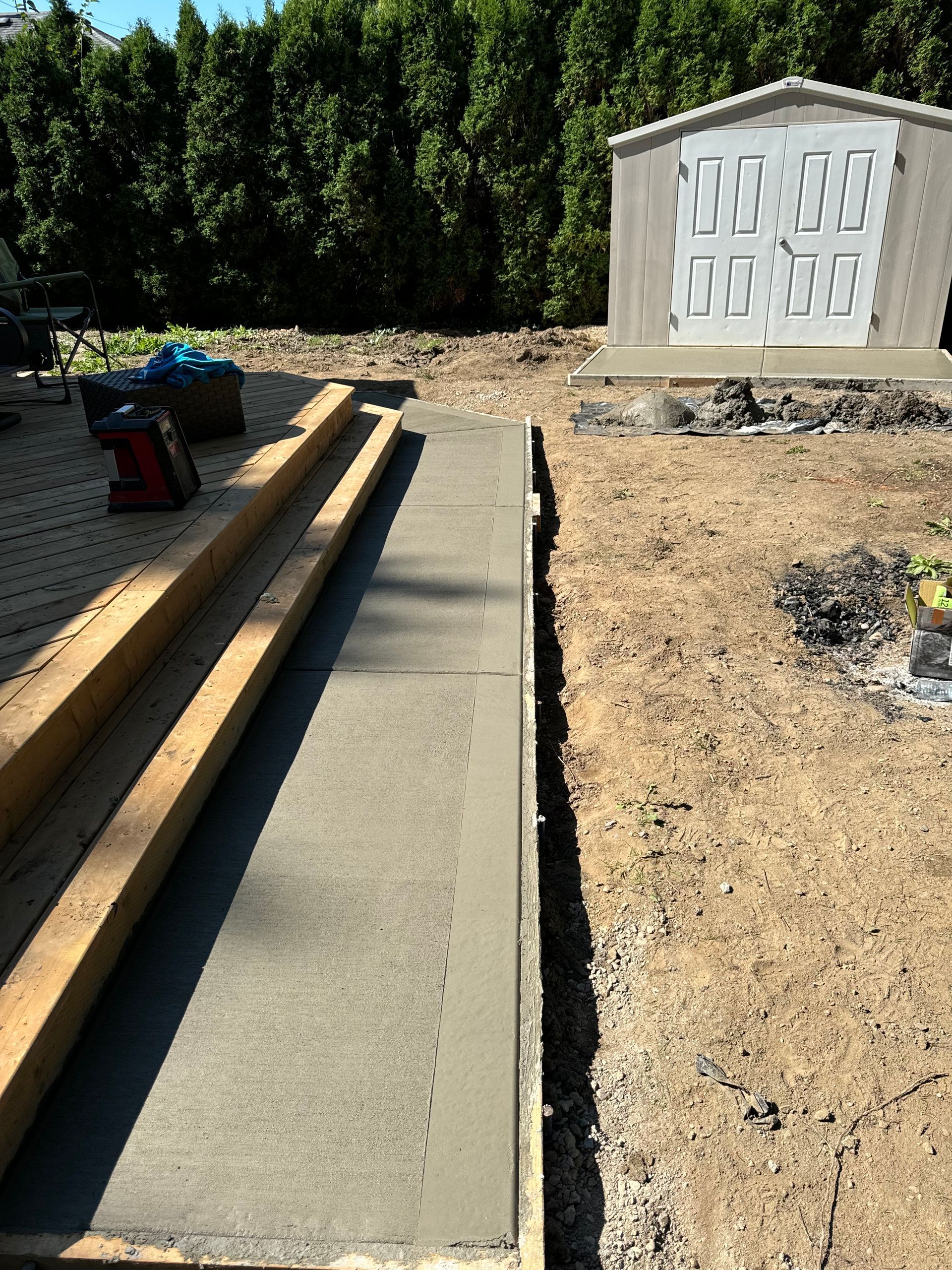 A concrete walkway is being built in front of a grave.