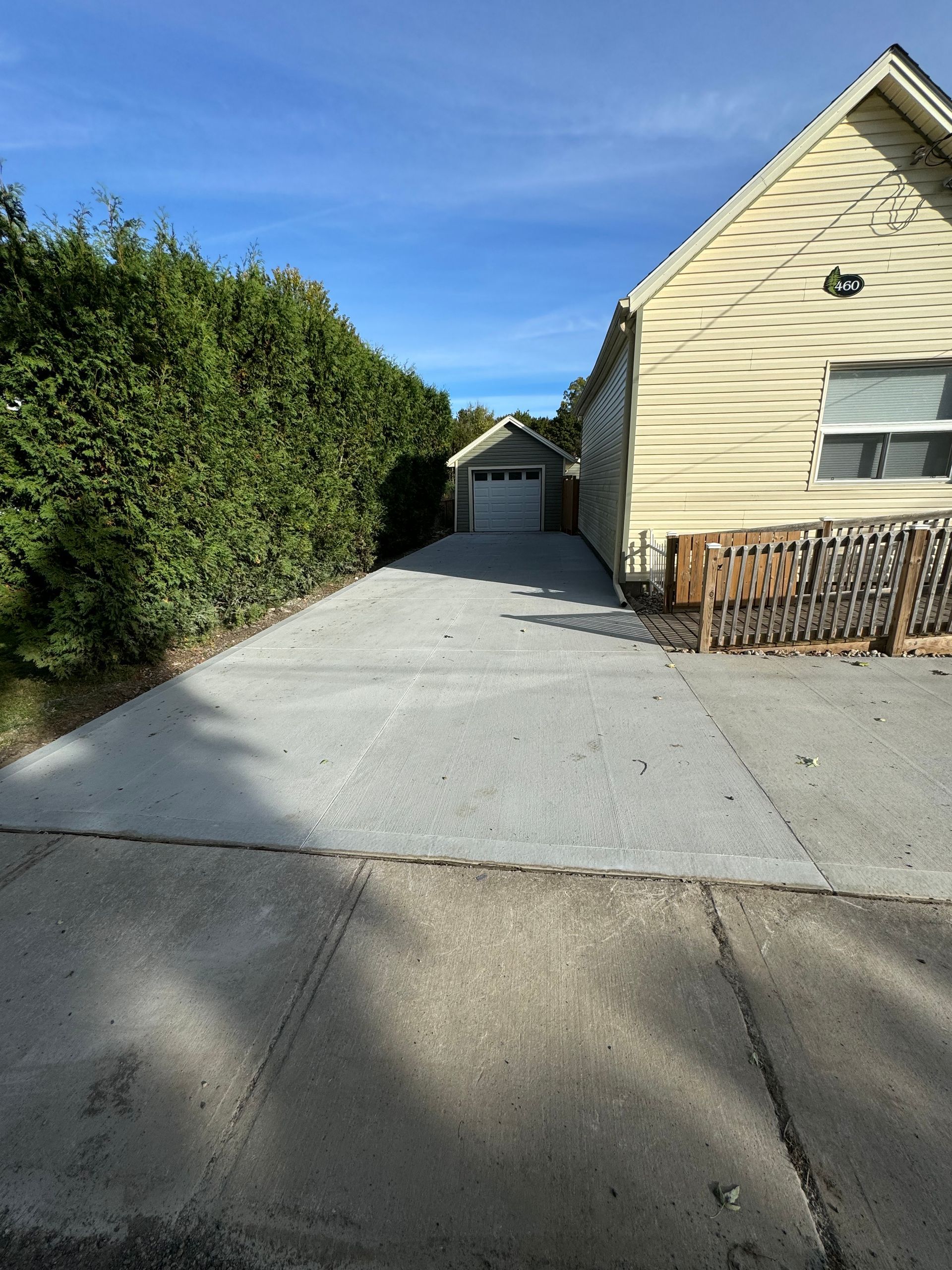 A concrete driveway leading to a house with a garage
