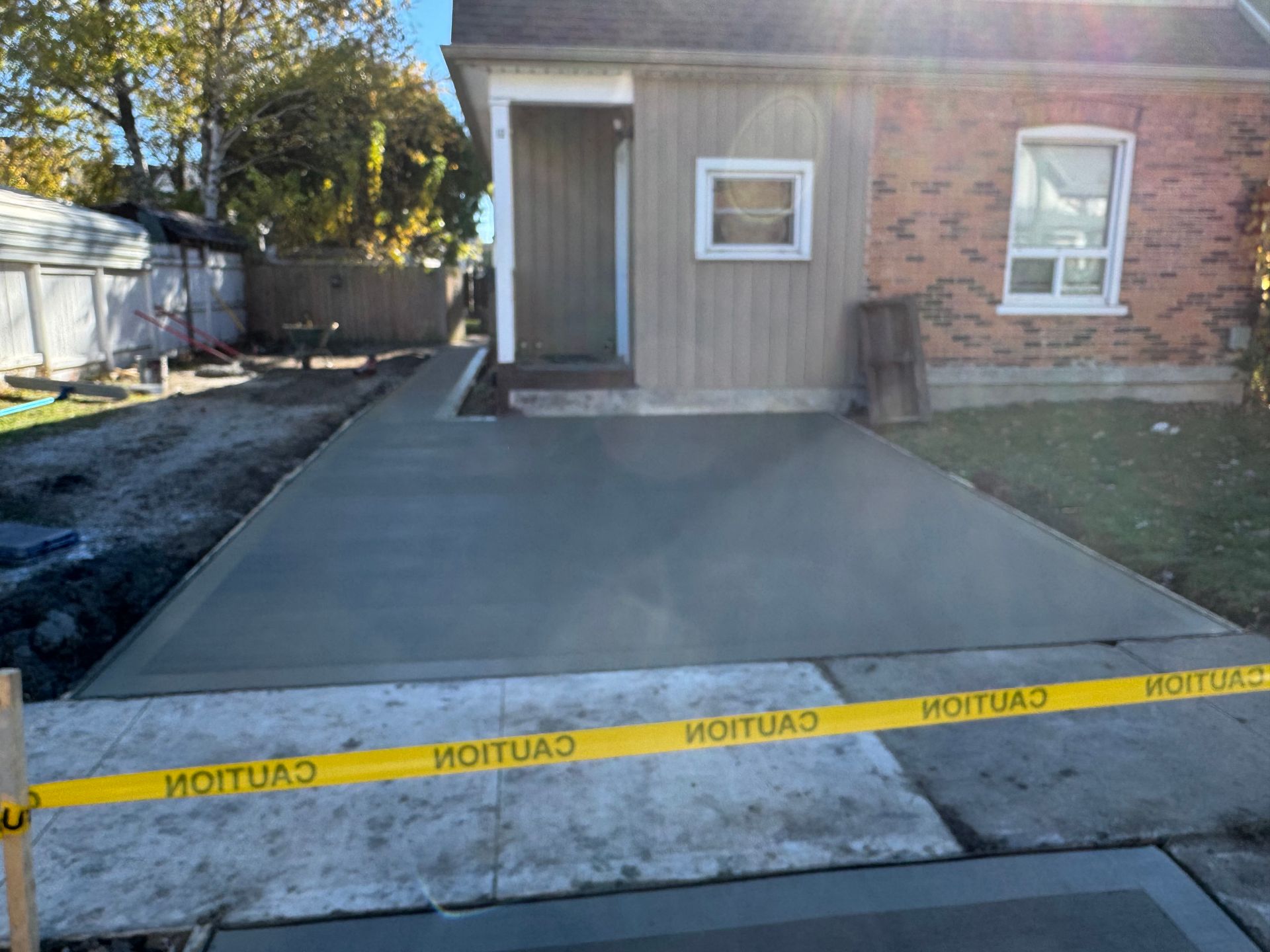 A concrete driveway is being built in front of a house.