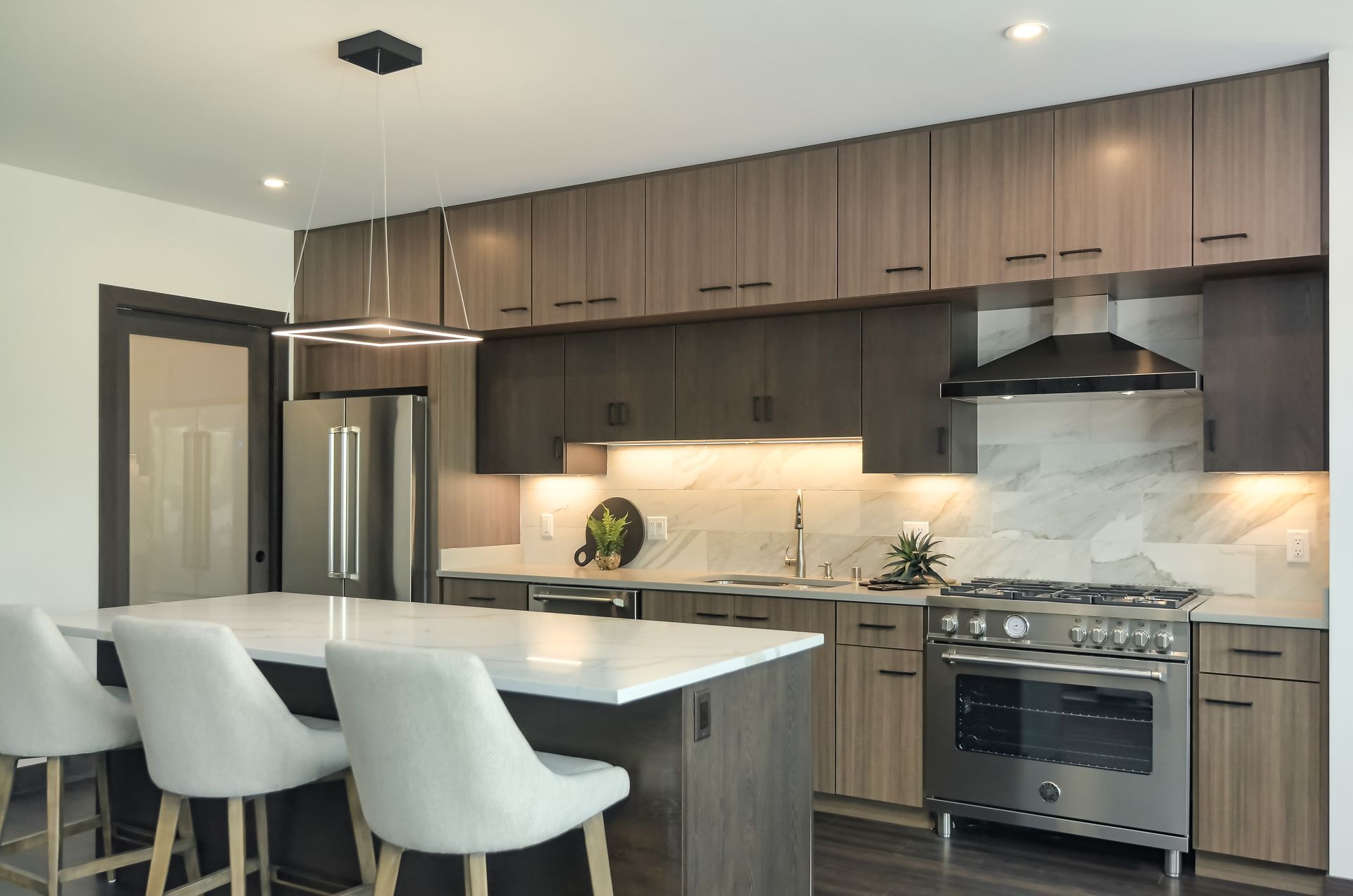 Modern kitchen with island, stainless steel appliances, and wood cabinetry.