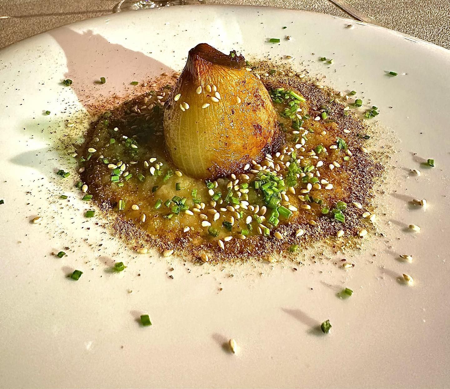 Un primo piano di un piatto di cibo con cipollotti sopra