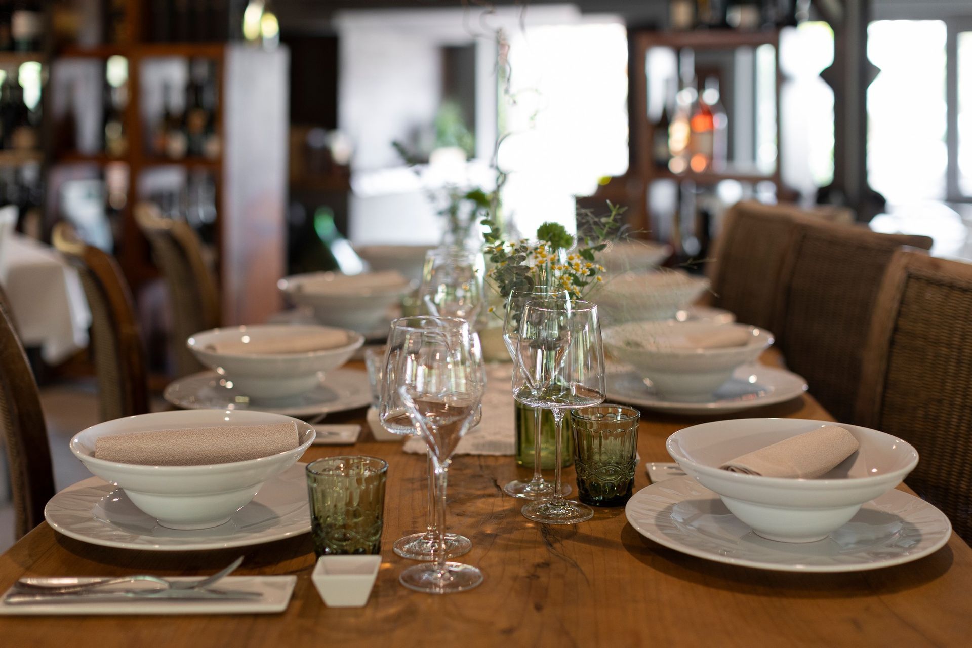 Un tavolo di legno con sopra piatti, ciotole, bicchieri e utensili.