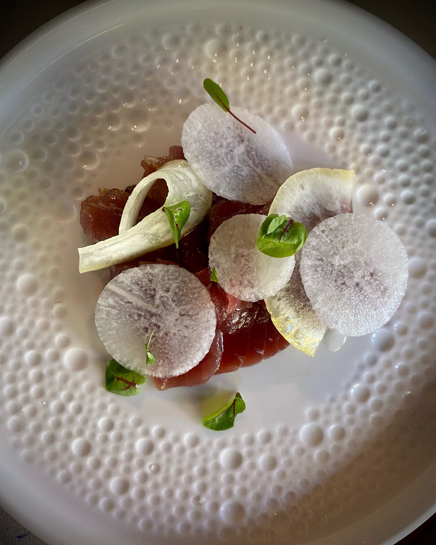 Un piatto bianco con sopra un'insalata di carne e verdure