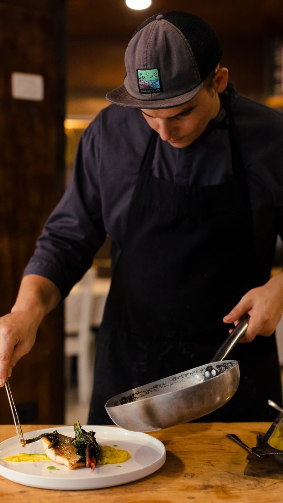 Uno chef sta preparando un piatto di cibo su un tavolo di legno.