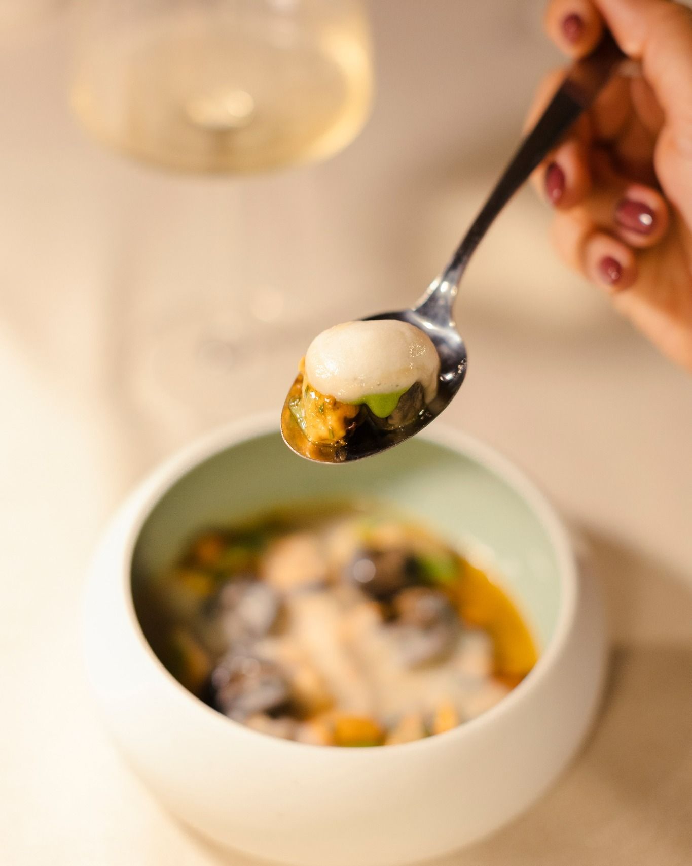 Una persona tiene un cucchiaio sopra una ciotola di cibo