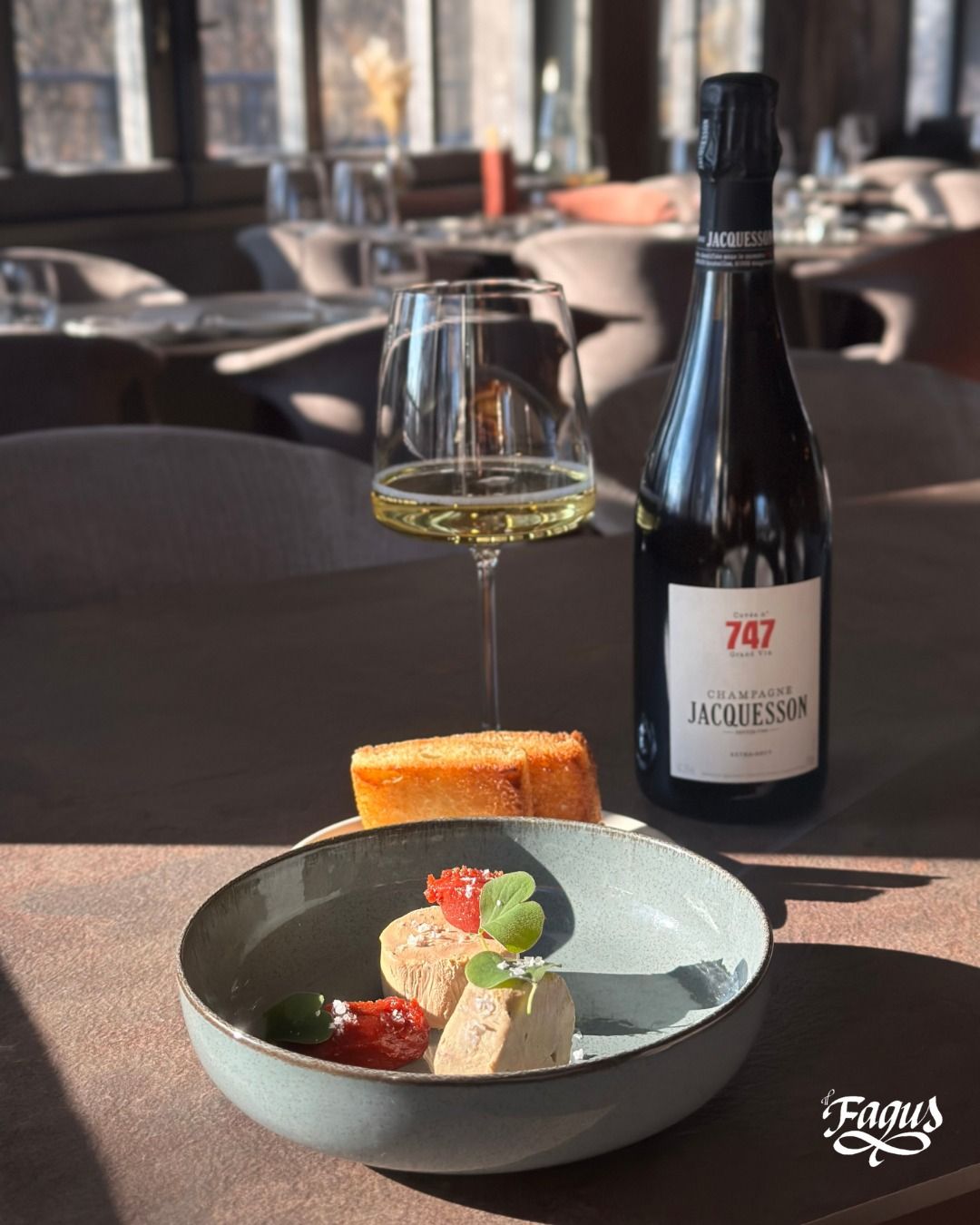 Una bottiglia di vino accanto a una ciotola di cibo su un tavolo.