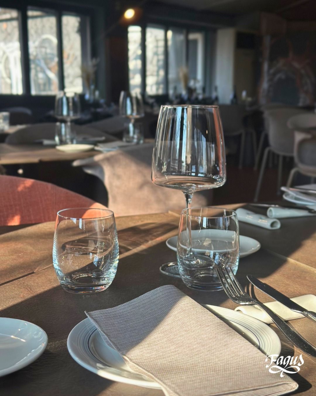 Un tavolo da ristorante con piatti, bicchieri, forchette e coltelli.