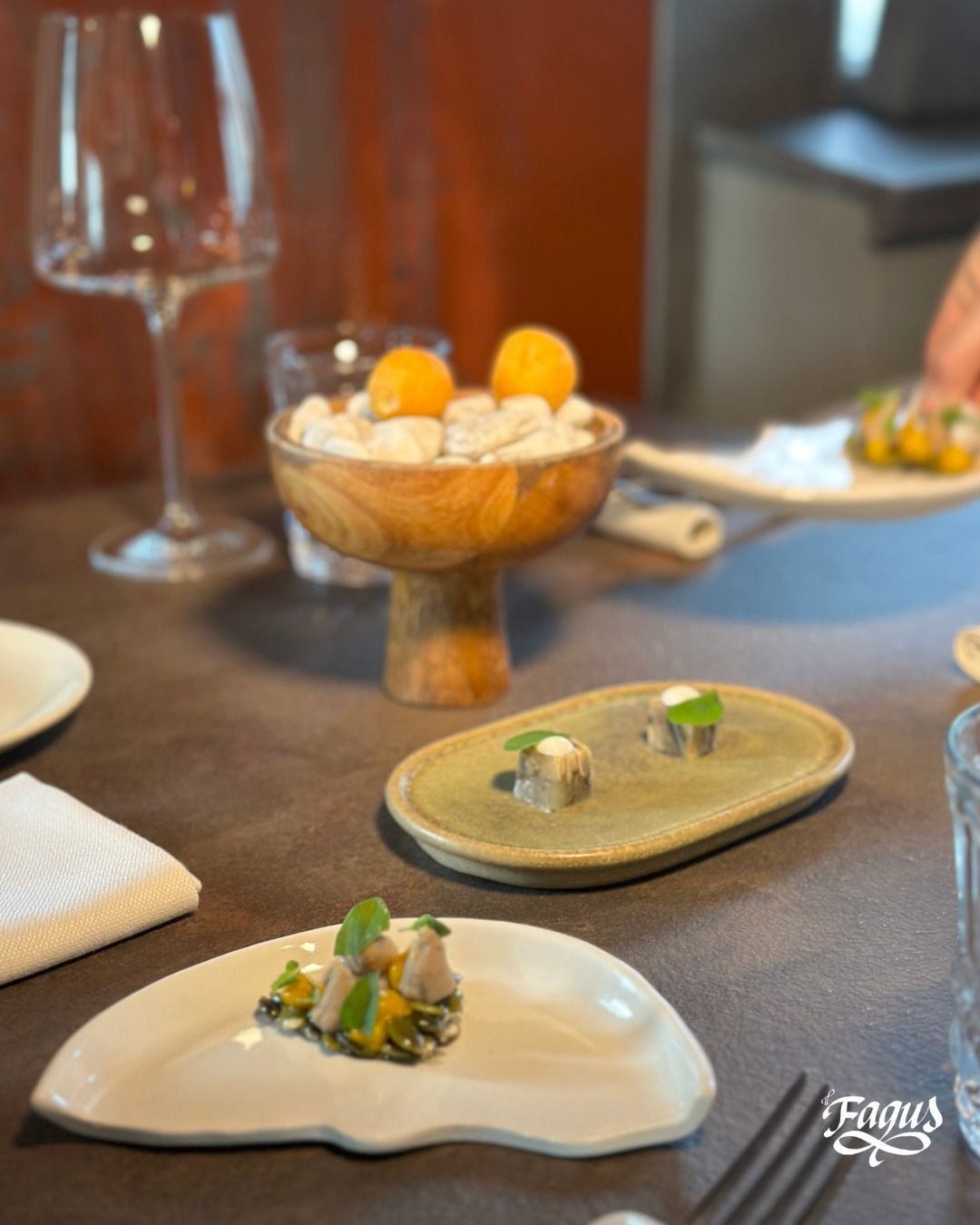 Un tavolo con piatti di cibo e un bicchiere di vino