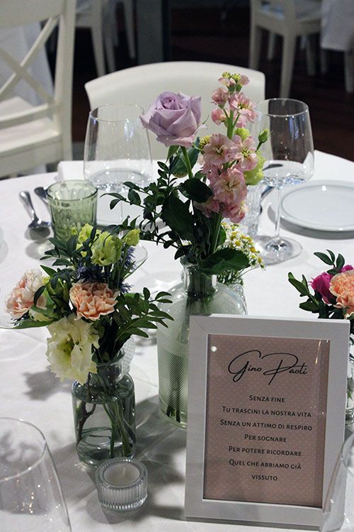 Un tavolo con fiori in vasi e un menù sopra.