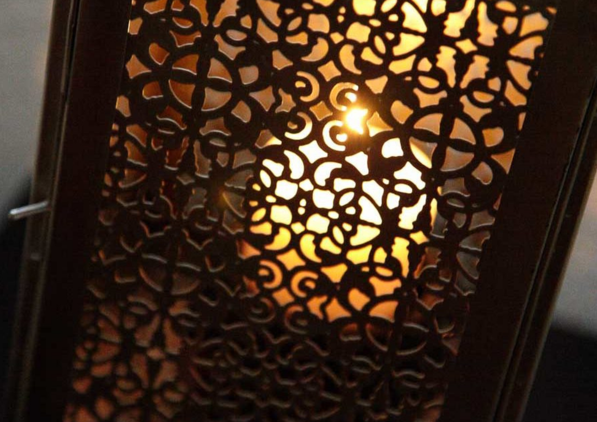 Nahaufnahme einer stimmungsvollen Laterne mit einer brennenden Kerze in der Mitte.