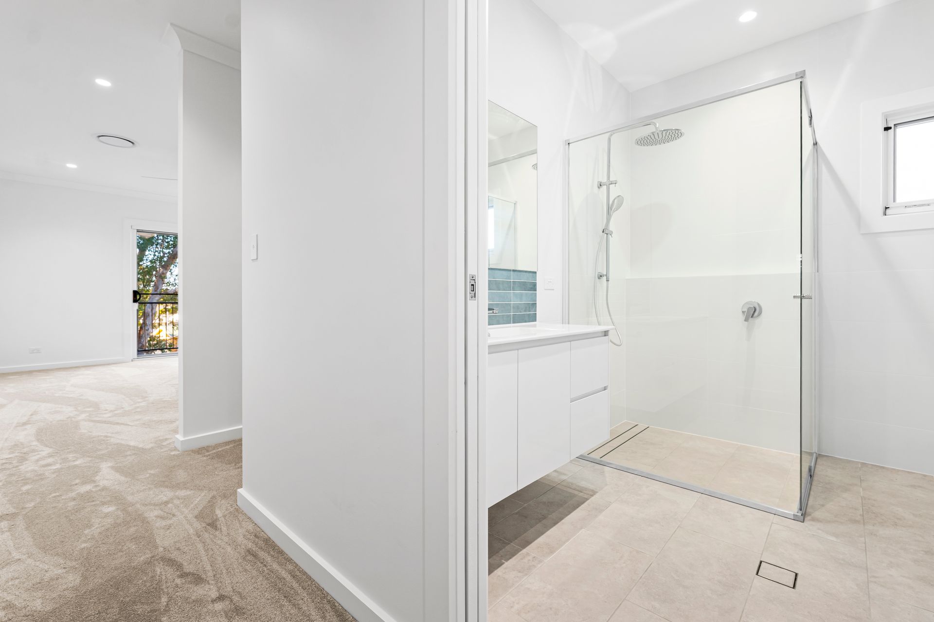 Bright, Modern Bathroom with Glass Shower, White Vanity, and Light-Colored Flooring — Designer Building Pty Ltd In Charmhaven, NSW