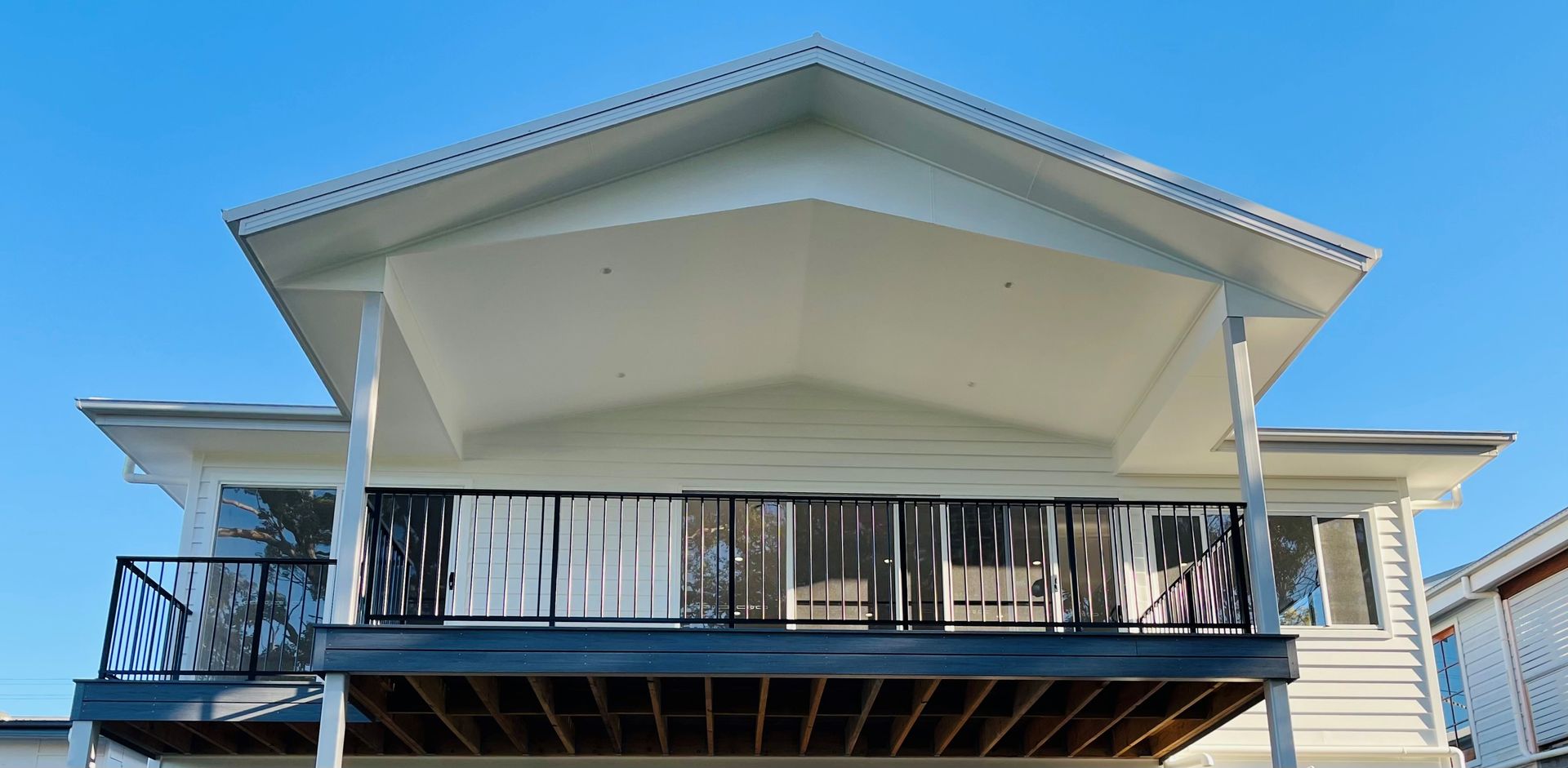 Two-Story House with White Siding, Dark Deck Railing, and A Covered Upper Deck — Designer Building Pty Ltd In Charmhaven, NSW
