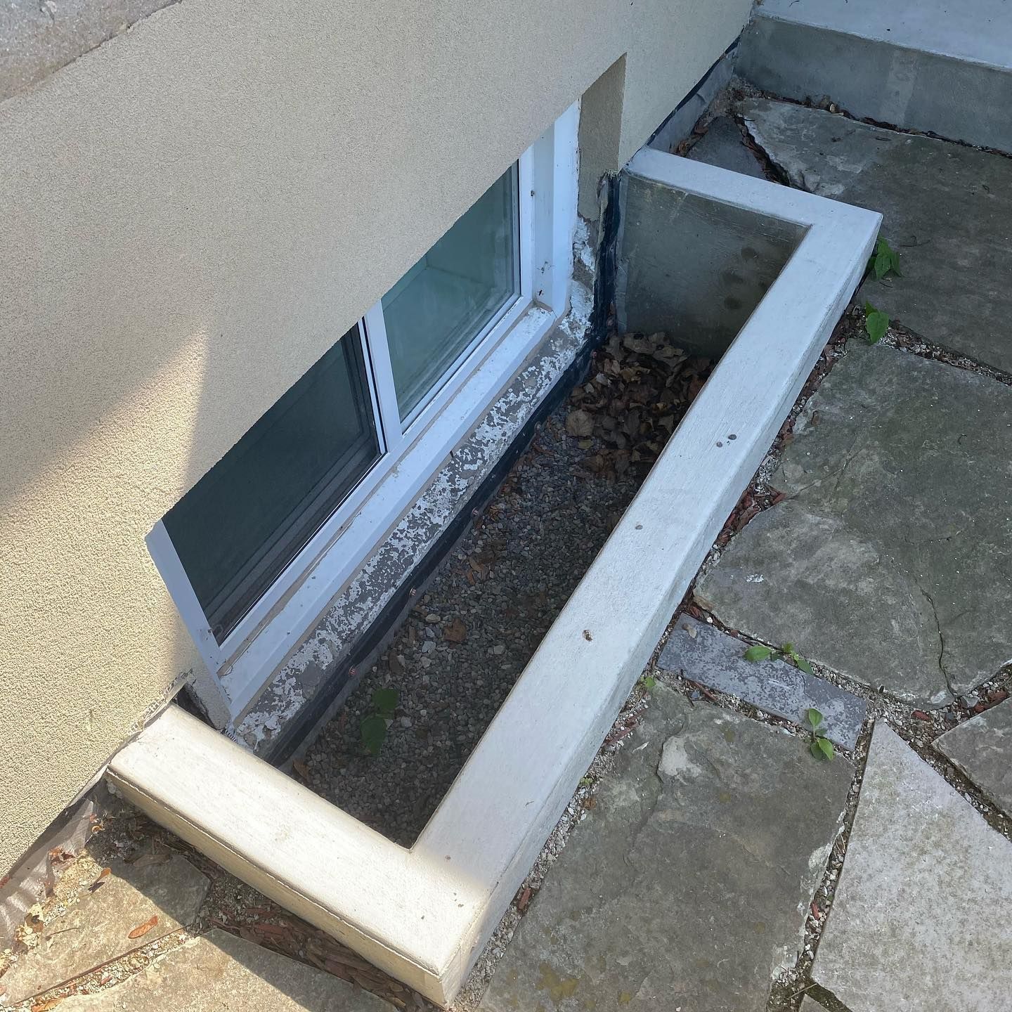 A window in the side of a building with a white frame