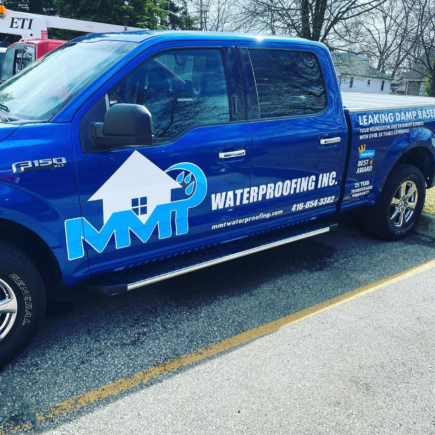 A blue truck with mmt waterproofing inc. written on the side