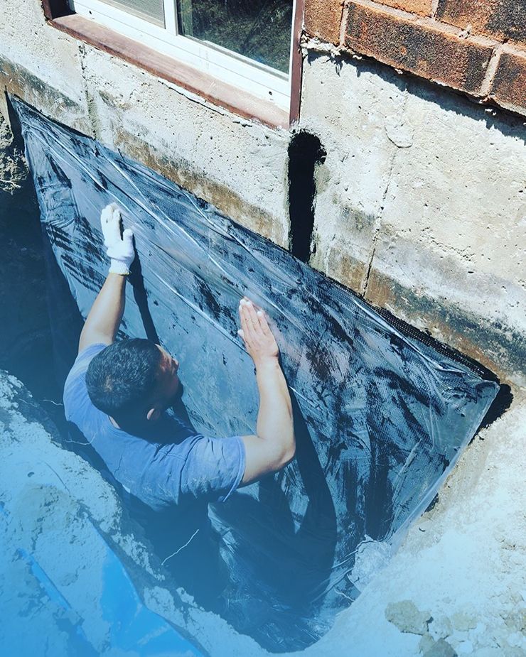 A man is working on the side of a brick building