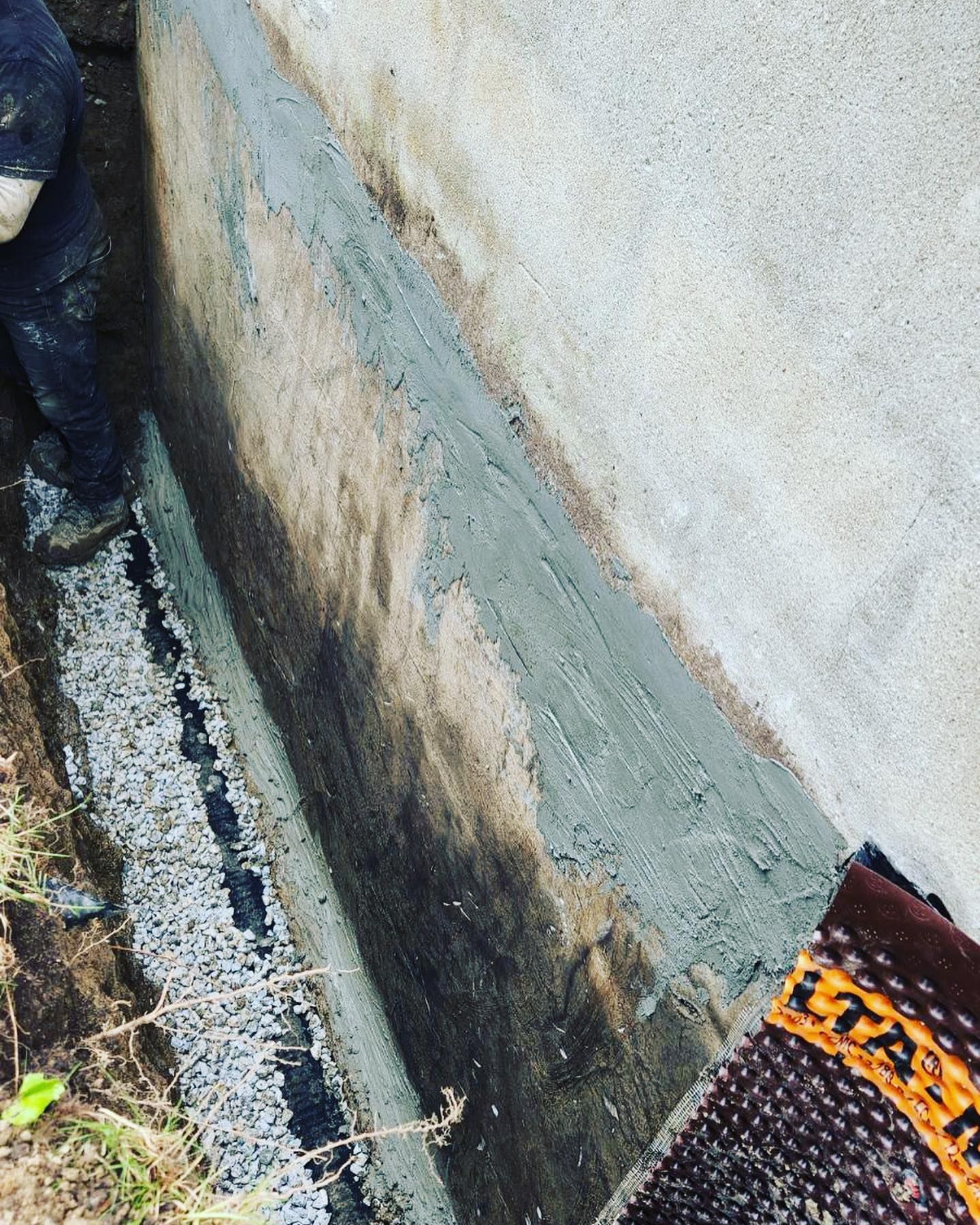 A person is working on a concrete wall.