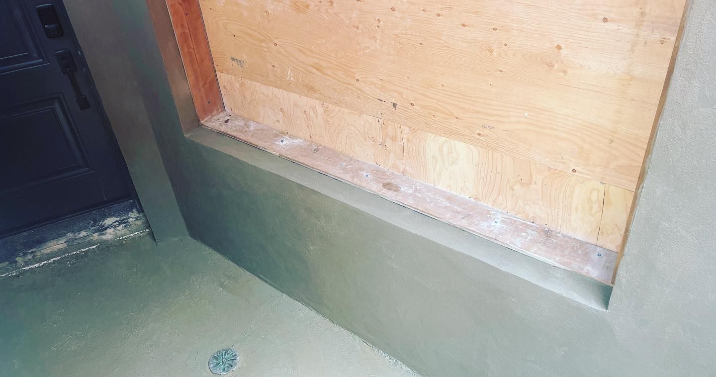 A corner of a wall with a window in it.