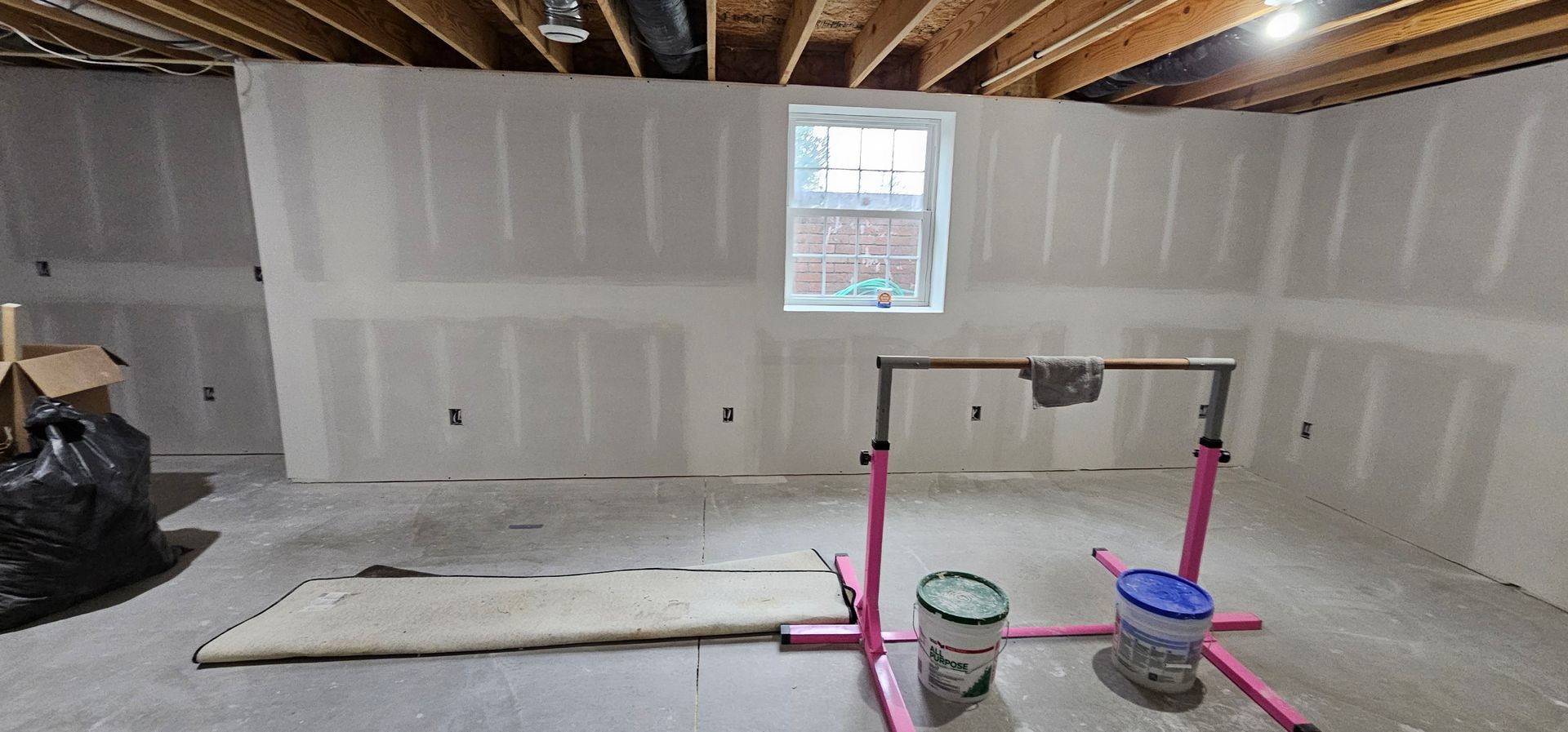 Empty finished basement with carpet, gray walls, recessed lights, and stairs on the right